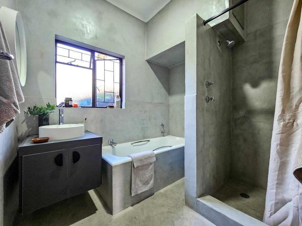 A bathroom finished in Mixx Cement — walls, floor and shower in one continuous micro-cement surface with no tiles or grout lines